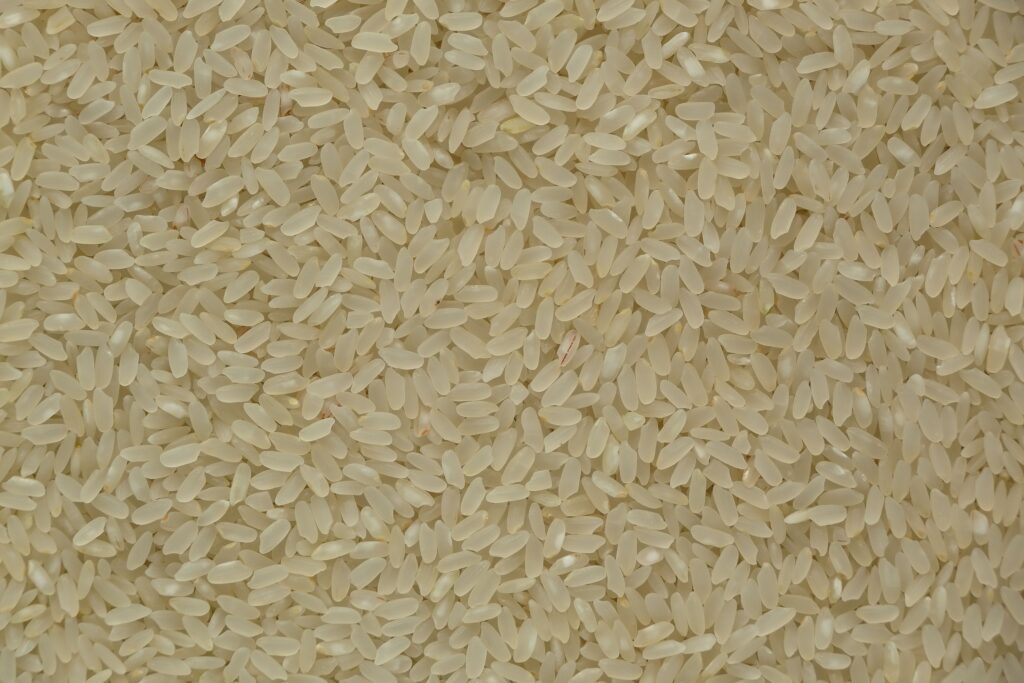 Close-up of uncooked white rice grains showing texture and detail, ideal for culinary themes.