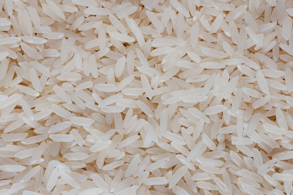 Detailed view of uncooked white rice grains, showcasing texture and pattern.